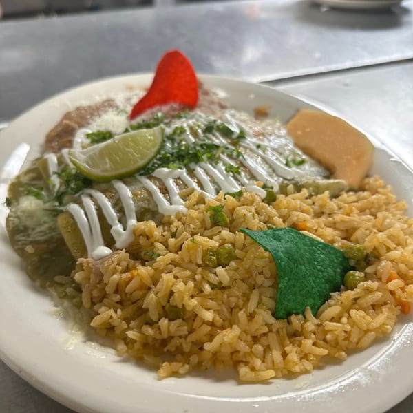Money Pancho's Mexican enchiladas with green sauce, rice, beans, lime, and red and green tortilla chips.