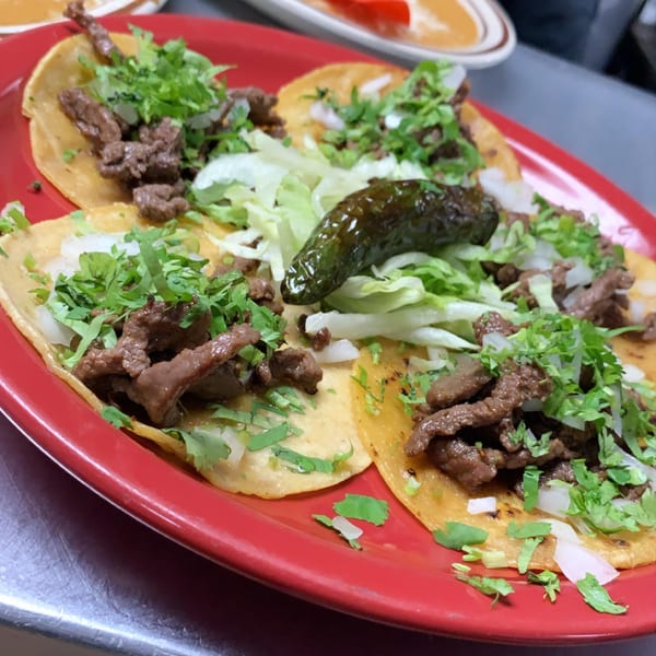Four Money Pancho Mexican Restaurant carne asada tacos with cilantro, onions, and a grilled jalapeño.